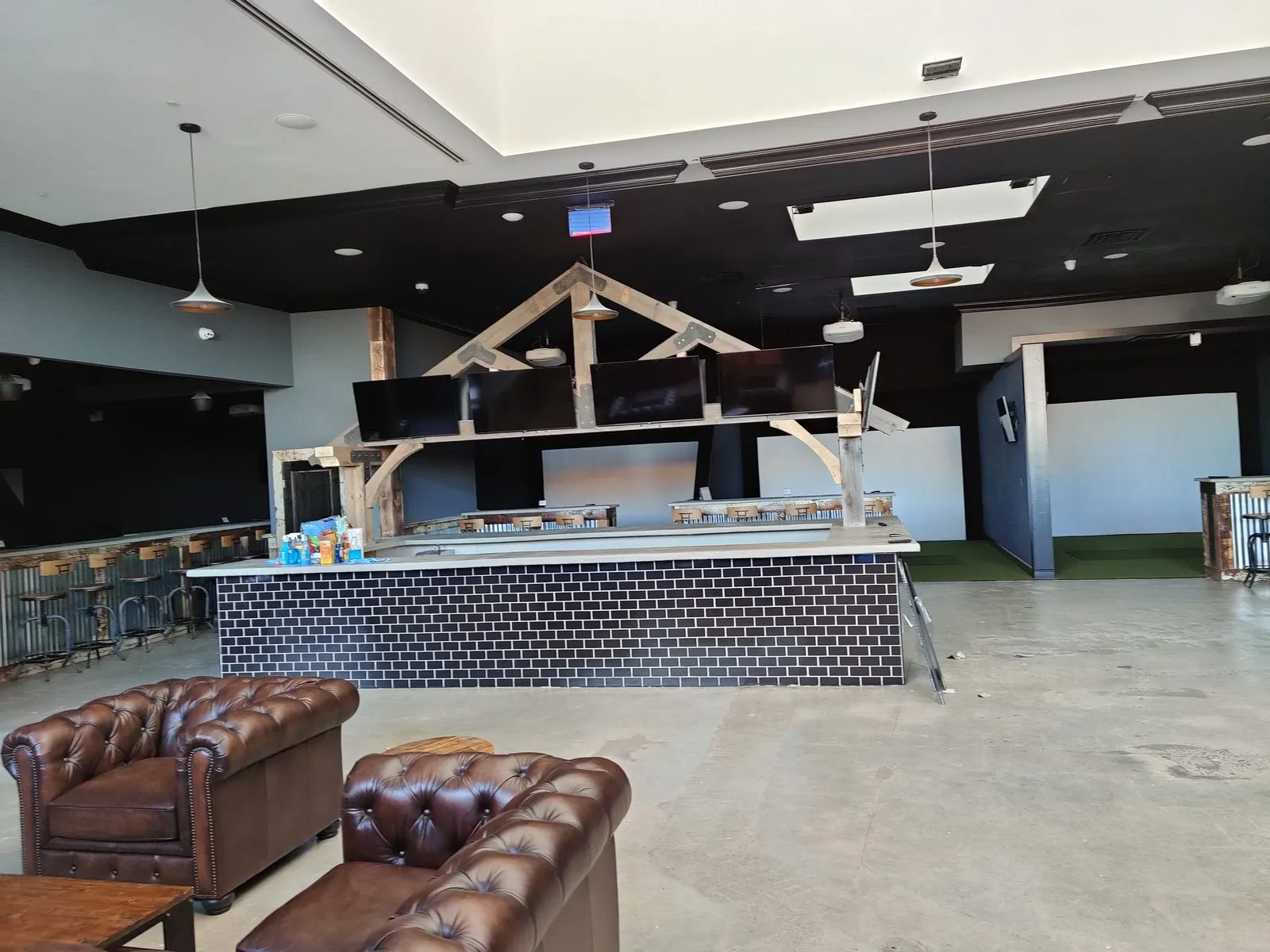 Venue lounge with leather seating, bar-mounted displays, and ambient lighting