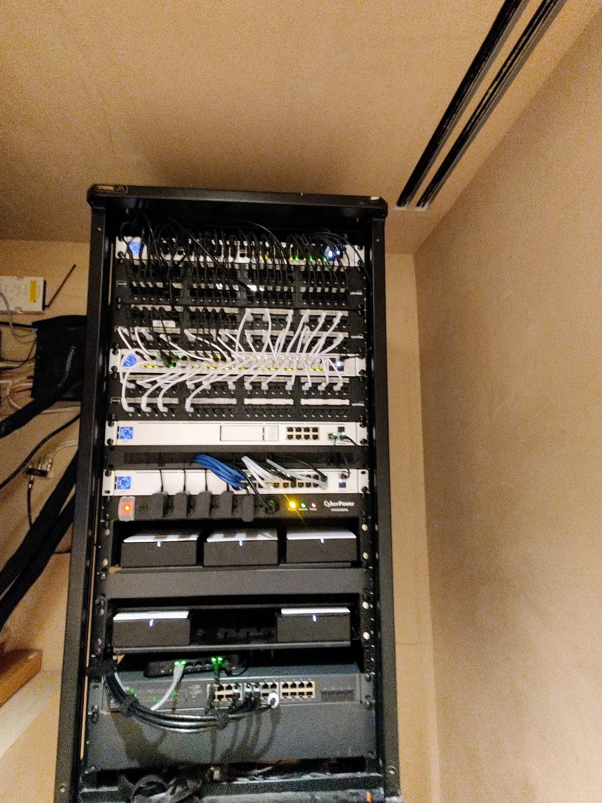 Network rack with patch panels, managed switches, and CyberPower UPS — single-office deployment